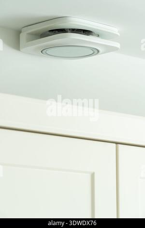 An interior view of a modern London home showcasing a sleek ceiling mounted air vent. The minimalist design complements the white cabinetry and contem Stock Photo