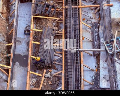 Overhead view of a construction site with steel reinforcements laid out for concrete foundation work, highlighting the essential elements of modern bu Stock Photo