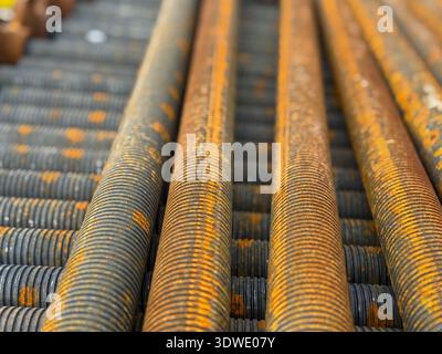 Close-up of rusted threaded metal rods used in construction, highlighting their connection and support role. These props are essential for structural Stock Photo