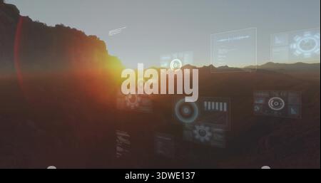 Displaying canyon sunrise with floating HUD panels over valley, sun peeking left ridgeline, haze Stock Photo