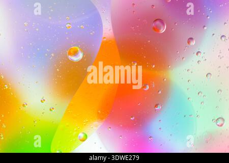 Abstract image of colorful bubbles in oil and water, blending vibrant hues of orange, pink, purple, green, and blue, creating an artistic background f Stock Photo