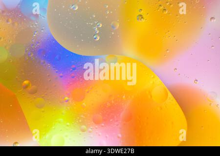 A captivating abstract composition showcasing vibrant colors merging in liquid-like forms. The image highlights hues of yellow, orange, blue, and purp Stock Photo