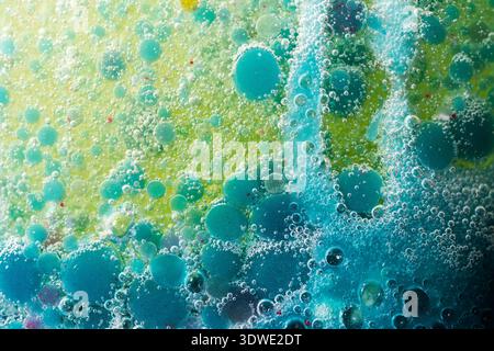 A mesmerizing abstract image featuring a close-up of floating bubbles in vivid blue and yellow hues. This original artistic composition creates a drea Stock Photo