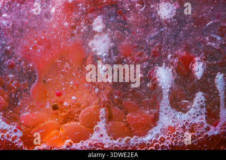 Original abstract artwork featuring vibrant red and purple bubbles. The artist's use of color and texture creates a dynamic and mesmerizing visual exp Stock Photo