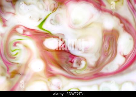 An abstract image of swirling brushstrokes in vibrant colors, reminiscent of impressionist art. The fluid motion of pink, green, and white creates a d Stock Photo