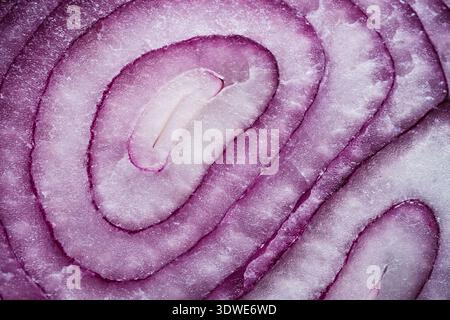 Close-up macro image showing the intricate texture of purple onion rings. The delicate layers reveal a blend of soft whites and vibrant purples Stock Photo
