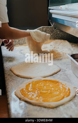 A skilled chef crafts authentic Neapolitan pizza dough by hand, capturing the essence of Italian tradition in a bustling pizzeria, showcasing artisan Stock Photo