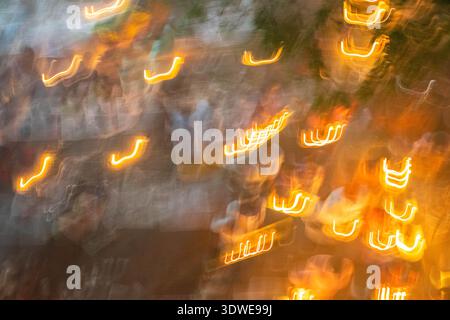 Sonargaon, Bangladesh - 10 November 2018: View of an abstract, blurry scene of vibrant orange lights dancing amidst a hazy, dreamlike atmosphere. Stock Photo