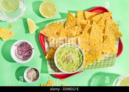 Enjoy a vibrant presentation of Mexican nachos paired with creamy guacamole. The crispy corn chips and savory avocado blend offer a delightful fusion Stock Photo