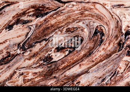 A close-up view of a rich chocolate ice cream texture, showcasing creamy swirls of chocolate in intricate patterns, capturing the indulgent and mouthw Stock Photo