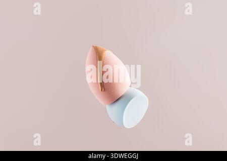 Soft pastel makeup sponges with a foundation sample on top, showcasing a minimalist beauty product layout. Ideal for cosmetics and skincare promotions Stock Photo
