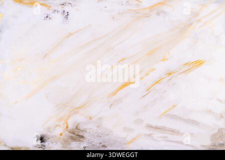 Abstract acrylic paint background featuring soft golden and gray hues on a white canvas. The organic, flowing patterns create a sense of elegance and Stock Photo