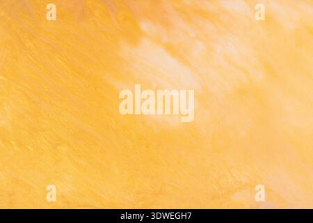 Warm-toned abstract acrylic paint background featuring dynamic hues of orange and yellow. The swirling patterns and soft gradients evoke a sense of en Stock Photo