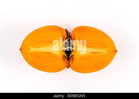 A freshly sliced persimmon is displayed on a plain white background. The vibrant orange hue of the fruit highlights its freshness and nutritional valu Stock Photo