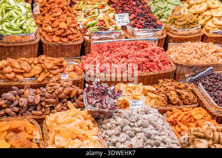 A vibrant display of assorted dried fruits in neat wicker baskets. This colorful arrangement highlights the variety, texture, and natural patterns fou Stock Photo