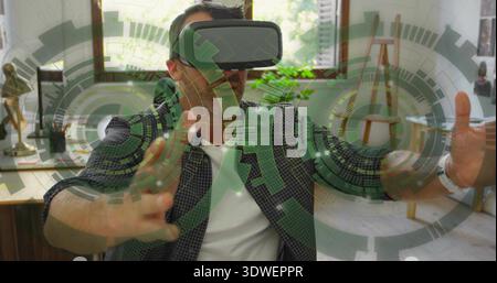 Reaching man wearing checkered shirt and VR headset, using translucent green HUD in home office Stock Photo
