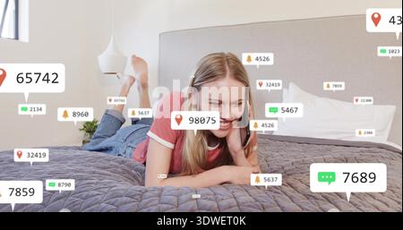 Lying woman in red T-shirt and jeans holding smartphone on bed at home, with notification overlays Stock Photo