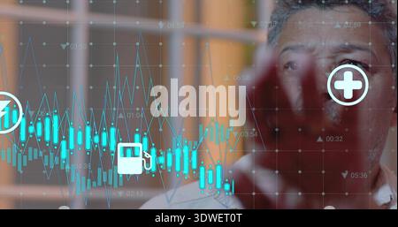 Studying mature man in light shirt viewing screen in office, with teal charts, icons, copy space Stock Photo
