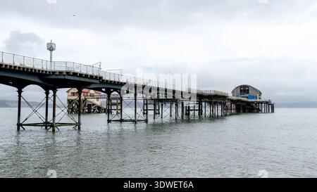 Mumbles Pier extends gracefully over the gentle waters of Swansea Bay, providing a scenic view and a tranquil spot for visitors in Wales. The structur Stock Photo