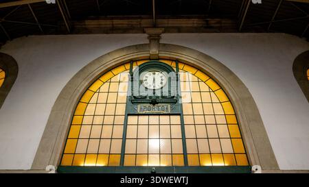 A beautifully crafted clock adorns the entrance of Sao Bento Station in Porto, Portugal. The architecture captures the blend of history and artistry, Stock Photo