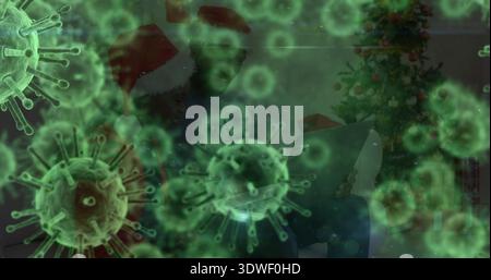 Watching man and child wearing Santa-hats using laptop on couch at home, green virus overlay, tree Stock Photo