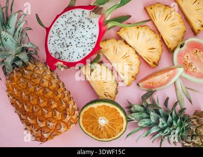 A vibrant selection of exotic fruits, including pineapple, dragon fruit, and guava, is arranged against a colorful background, showcasing their fresh, Stock Photo