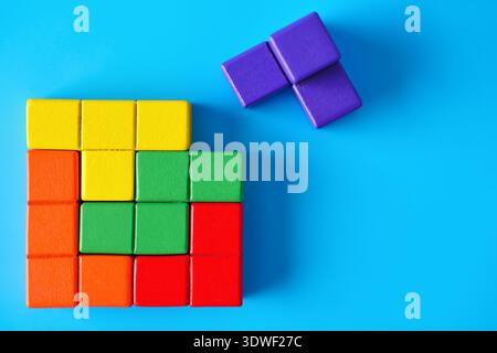Close-up of colorful jigsaw pieces on a blue background, symbolizing the complexity and uniqueness of autism. Represents mental health and cognitive d Stock Photo