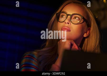 Blond woman using laptop and working late Stock Photo