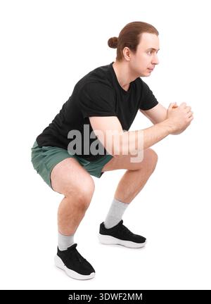 Side view of a fit man performing squat exercises isolated on white. Sporty male athlete with hair bun training legs and glutes during a workout. High Stock Photo