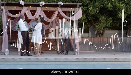 Exchanging vows bride and groom standing at poolside patio by wooden pergola, bride in white dress Stock Photo