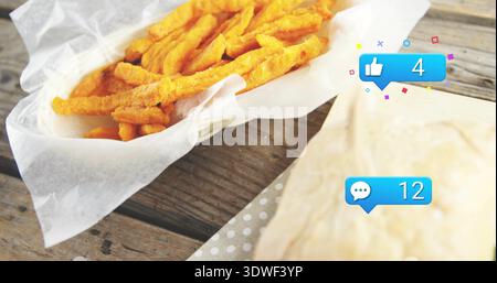 Showing basket of curly fries left on table, with wrapped sandwich, polka-dot napkin and blue icons Stock Photo