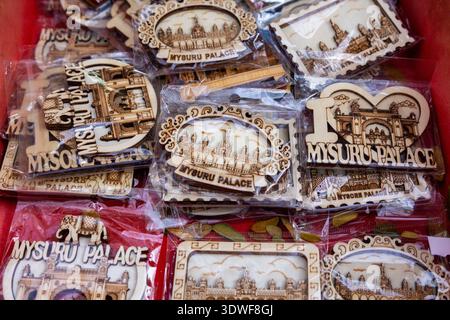 intricately carved wooden souvenirs depicting Mysore Palace, arranged in a red box with various oval, heart-shaped, and rectangular frames Stock Photo