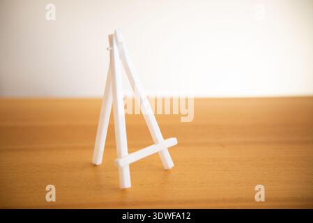 Small white easel mockup on a table background Stock Photo