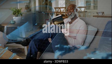 Reading man in pink shirt on sofa in living room holding ENDLESS SUNSETS paperback, digital overlay Stock Photo