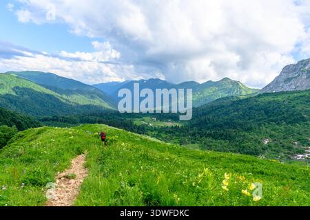 Group of diverse tourists or hikers walks on mountain top Stock Photo
