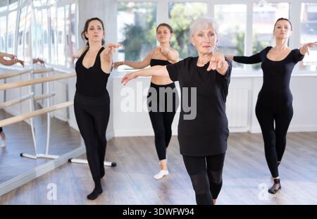 Elderly woman leading ballet class with female dancers Stock Photo