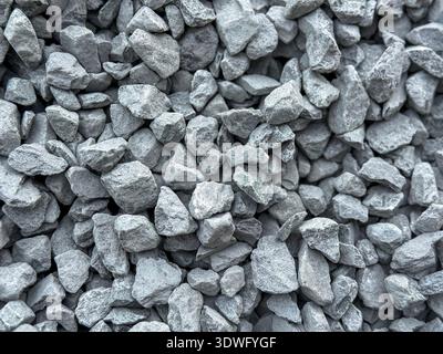 A close-up view of a pile of grey stones and gravel, showcasing the rough texture and natural irregular shapes. Ideal for use in construction, landsca Stock Photo