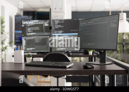 Workspace featuring multiple computer monitors displaying intricate programming code and algorithms, illustrating a developer environment for software engineering and data analysis. Stock Photo