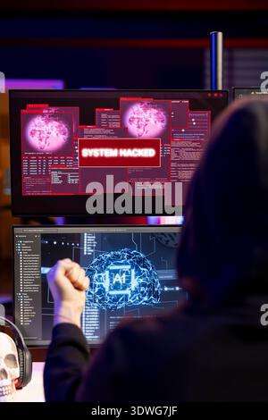 Hacker receiving system hacked message after attacking PCs using AI malware software. Rogue software developer in secret lair trying to hide online activity after stealing data Stock Photo