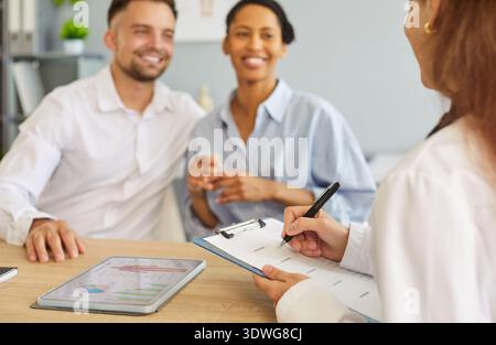 Happy young man sitting in medical clinic with wife planning pregnancy Stock Photo