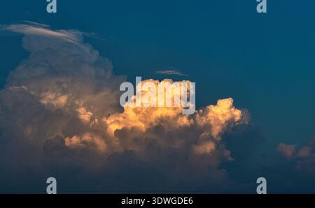Dramatic Golden Light Clouds Against Deep Blue Sky Background Stock Photo