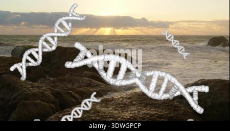 Displaying dominant white 3D DNA helix over rocky coastal shoreline at sunset with low clouds Stock Photo
