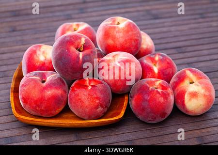 Delicious ripe peaches fruit on wooden surface in kitchen Stock Photo