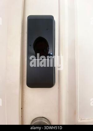 Electronic door lock mounted on a white door, highlighting its modern design and functionality, suitable for enhancing home security systems Stock Photo