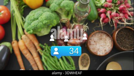 Displaying blue notification showing user icon 34 overlaying veggies and kitchenware on tabletop Stock Photo
