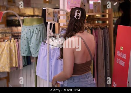 BANGKOK, THAILAND-FEB 1, 2026: Female tourist shopping in market, traveler exploring outdoor market, rear view, Chatuchak Market. Stock Photo