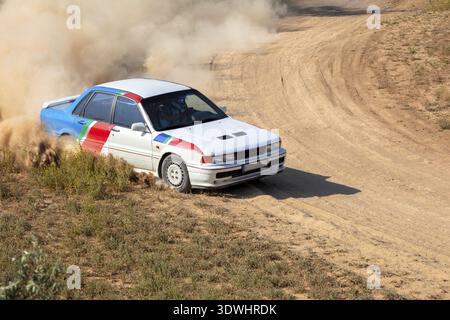 Sunny summer day. Dirt rally track. Rally car creates a lot of dust on a turn, Odesa, Ukraine Stock Photo