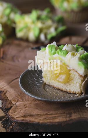 Beautiful cupcakes on wooden background, closeup. Spring time cupcakes with tulips. Rustic style. Cupcake inside with lemon kurd Stock Photo
