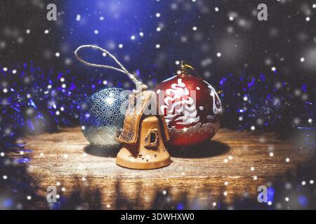 Christmas composition of Christmas decorations: two balls and a clay house. Studio photo with artificial snowflakes. The Central composition of the fr Stock Photo