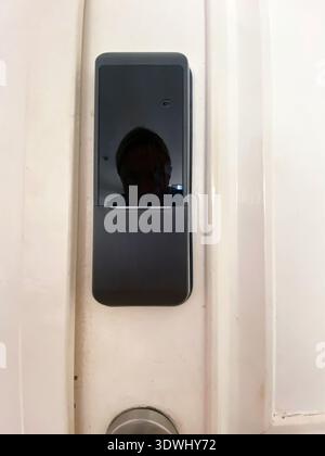 Electronic door lock mounted on a white door, highlighting its modern design and functionality, suitable for enhancing home security systems Stock Photo